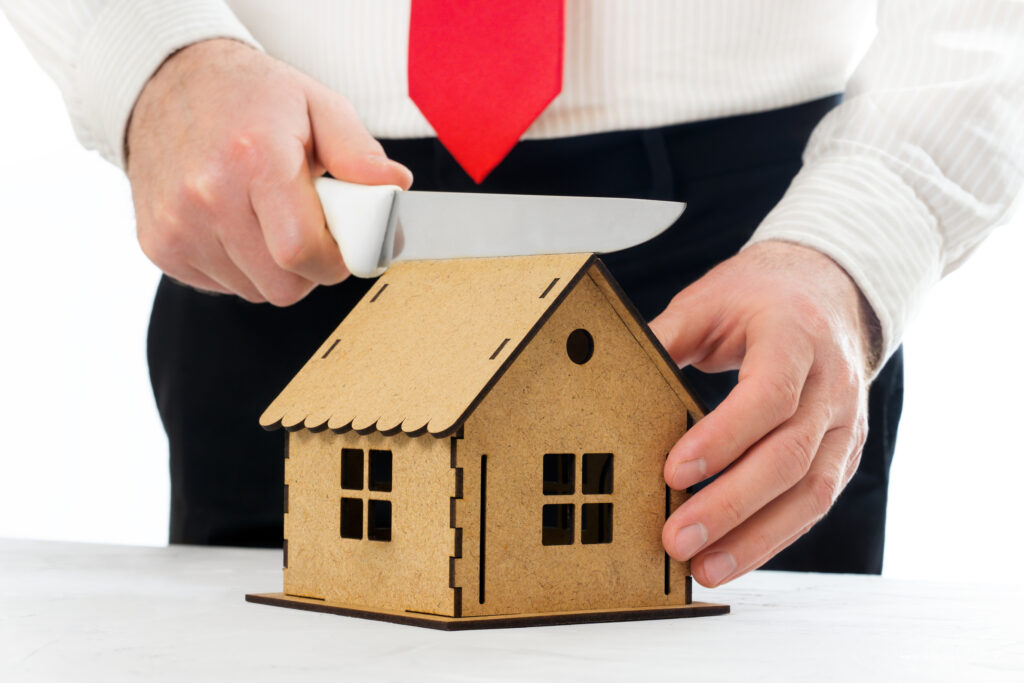 cutting house in half with knife to represent dividing retirement assets