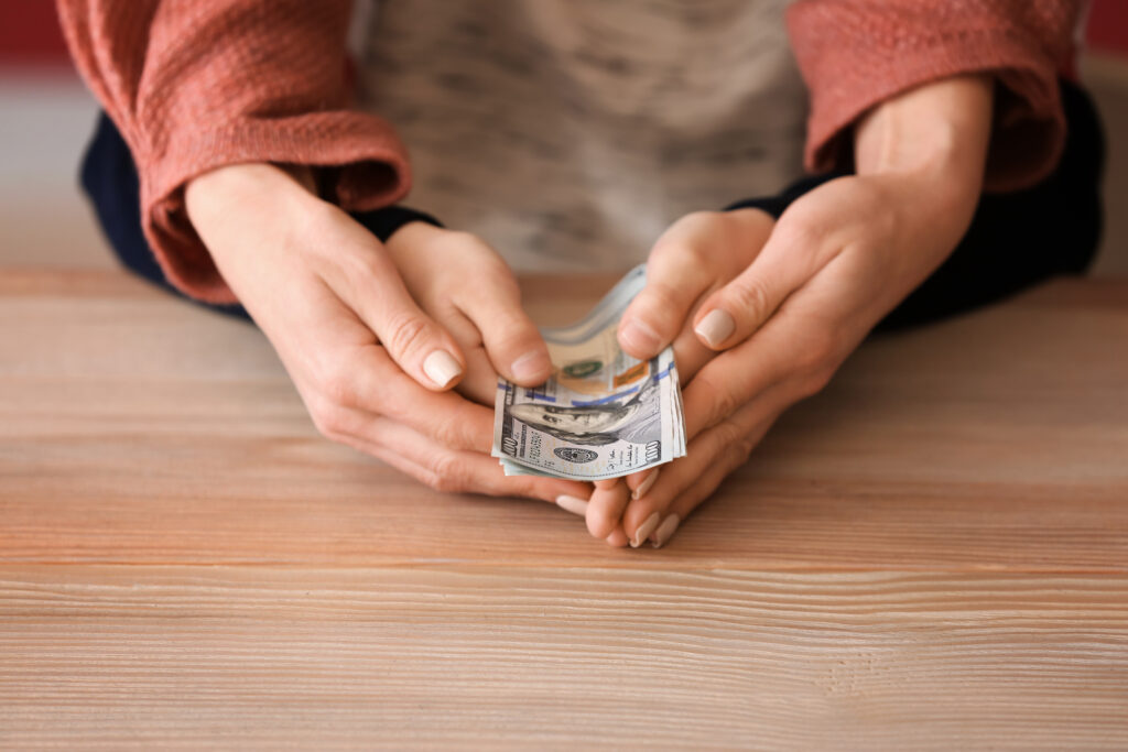 parent and child's hands with child support cash